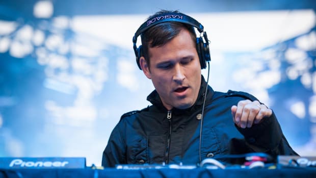 Kaskade during a DJ set with headphones on.