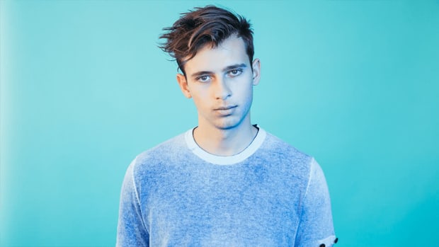 A press photo of Flume (real name Harley Edward Streten) standing in front of a sky blue background.