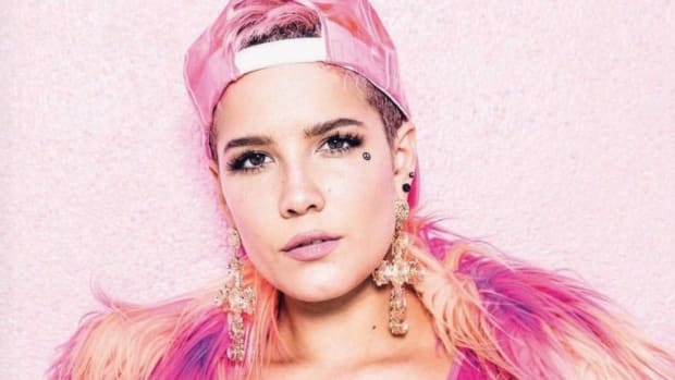 Halsey wearing a pink hat and feather boa in a photo taken for a Playboy article.