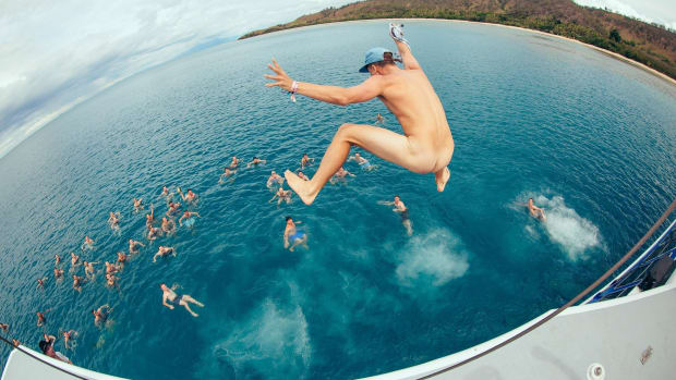 A photo of Australian DJ/producer and surfer Paul Fisher A.K.A. FISHER diving into the ocean nude.