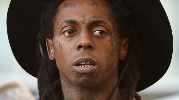 A head shot of rapper Lil Wayne wearing a black hat.