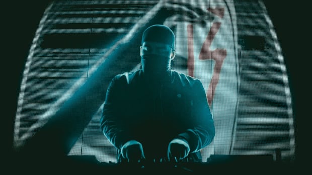 A press photo of anonymous DJ/producer 13 during a performance.