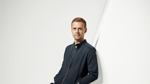 A photo of Dutch DJ/producer Armin van Buuren leaning againsta large letter A.