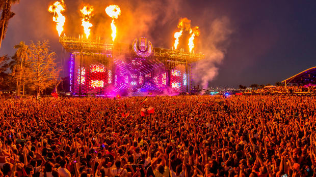A photo of the Ultra Music Festival main stage at the 2019 event with fire/pyrotechnics shooting out above a crowd.