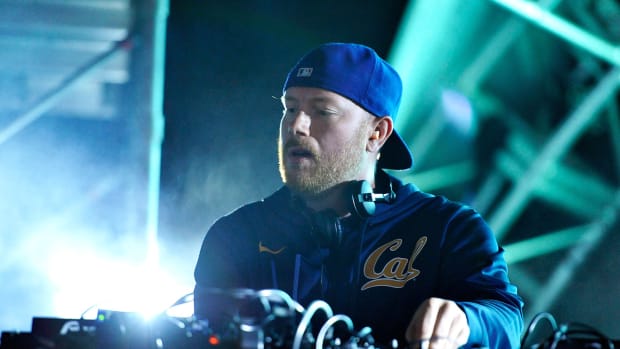 A color photo of Swedish DJ/producer Eric Prydz during a performance wearing blue over a blue background.