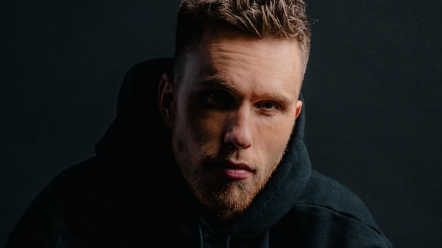 Nicky Romero wearing a black hoodie over a black background in a 2020 press photo.