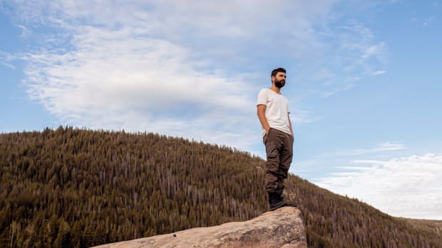 Lane 8 standing on top of a rock against a scenic mountain.