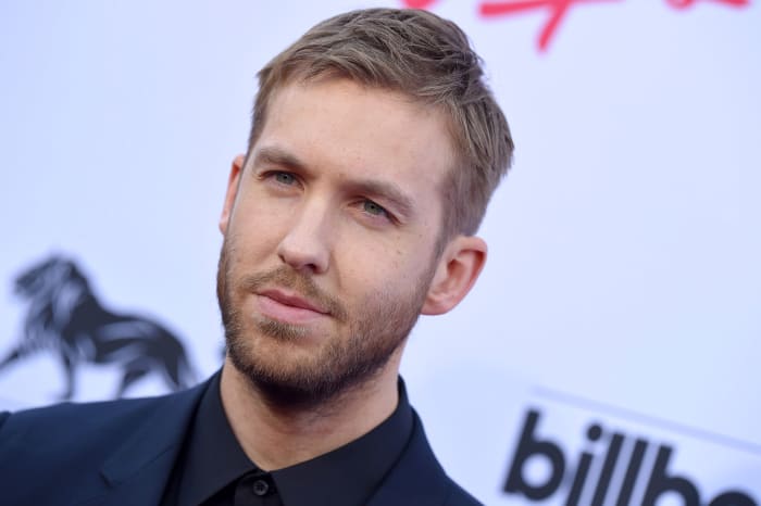 Photo of Scottish DJ/producer Calvin Harris in front of a splash with Billboard's logo on it.