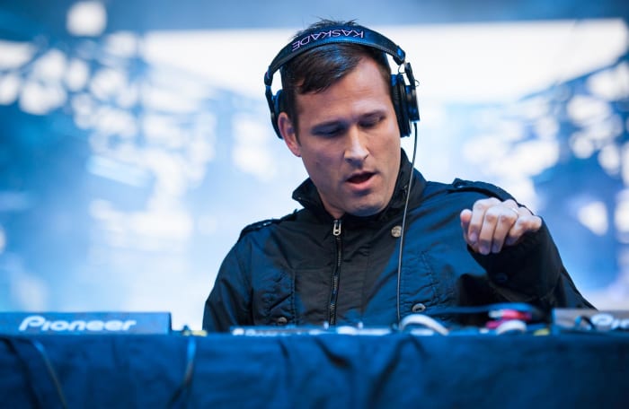 Kaskade during a DJ set with headphones on.