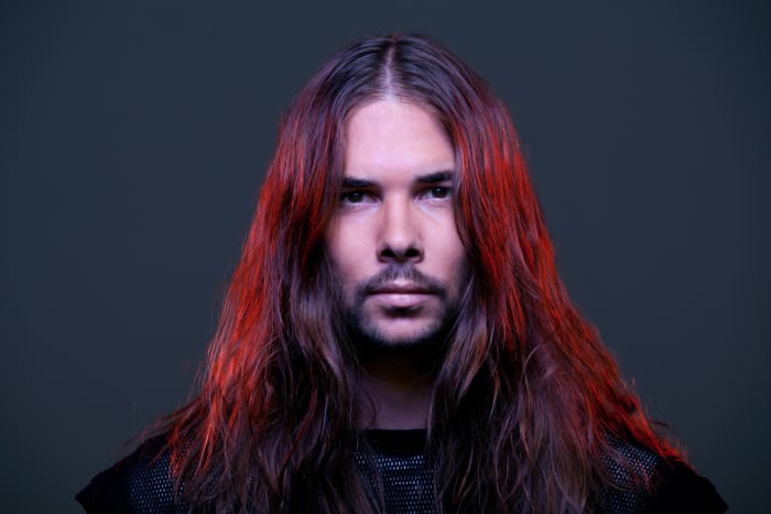 A head shot of DJ/producer Seven Lions A.K.A. Jeff Montalvo with bright red dyed hair.