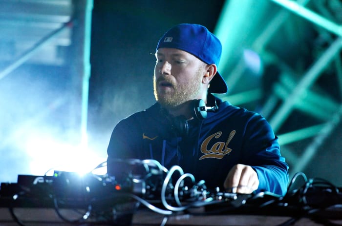 A color photo of Swedish DJ/producer Eric Prydz during a performance wearing blue over a blue background.