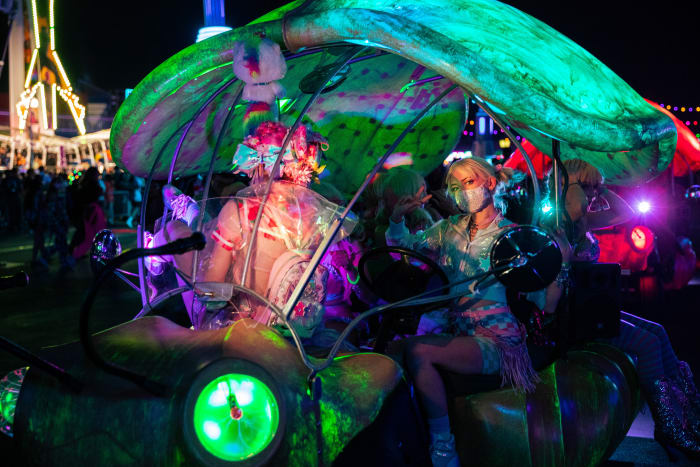 EDC Vegas 2021 performers drive an art car through the festival venue.