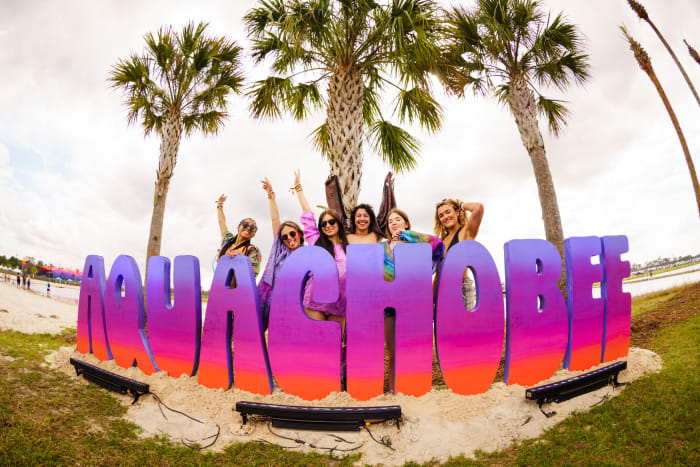 Fans pose at the Aquachobee beach at Okeechobee Music and Arts Festival 2022