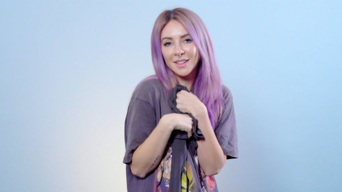 A press photo of Australian DJ/producer Alison Wonderland (real name Alexandra Sholler) with purple hair over a blue background.