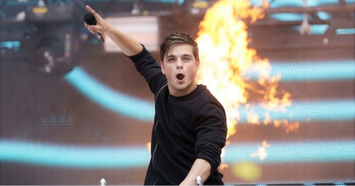 A photo of Dutch DJ/producer Martin Garrix (real name Martijn Garritsen) during a performance with fire in the background.