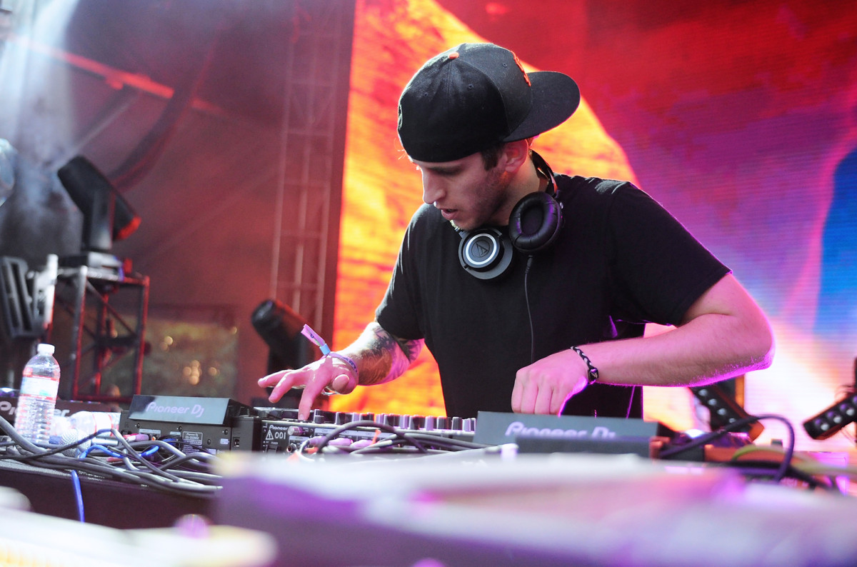 A color photo of DJ/producer Illenium (real name Nicholas D. Miller) during a performance.