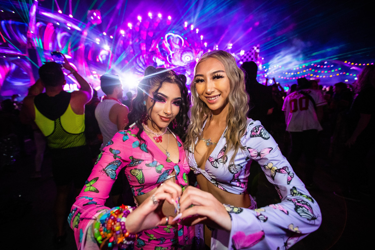 EDC Vegas 2021 attendees pose in front of the Kinetic Field stage.