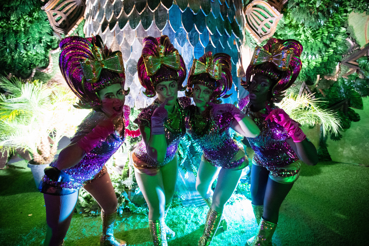 EDC Vegas performers pose inside the festival venue in front of an art installation.